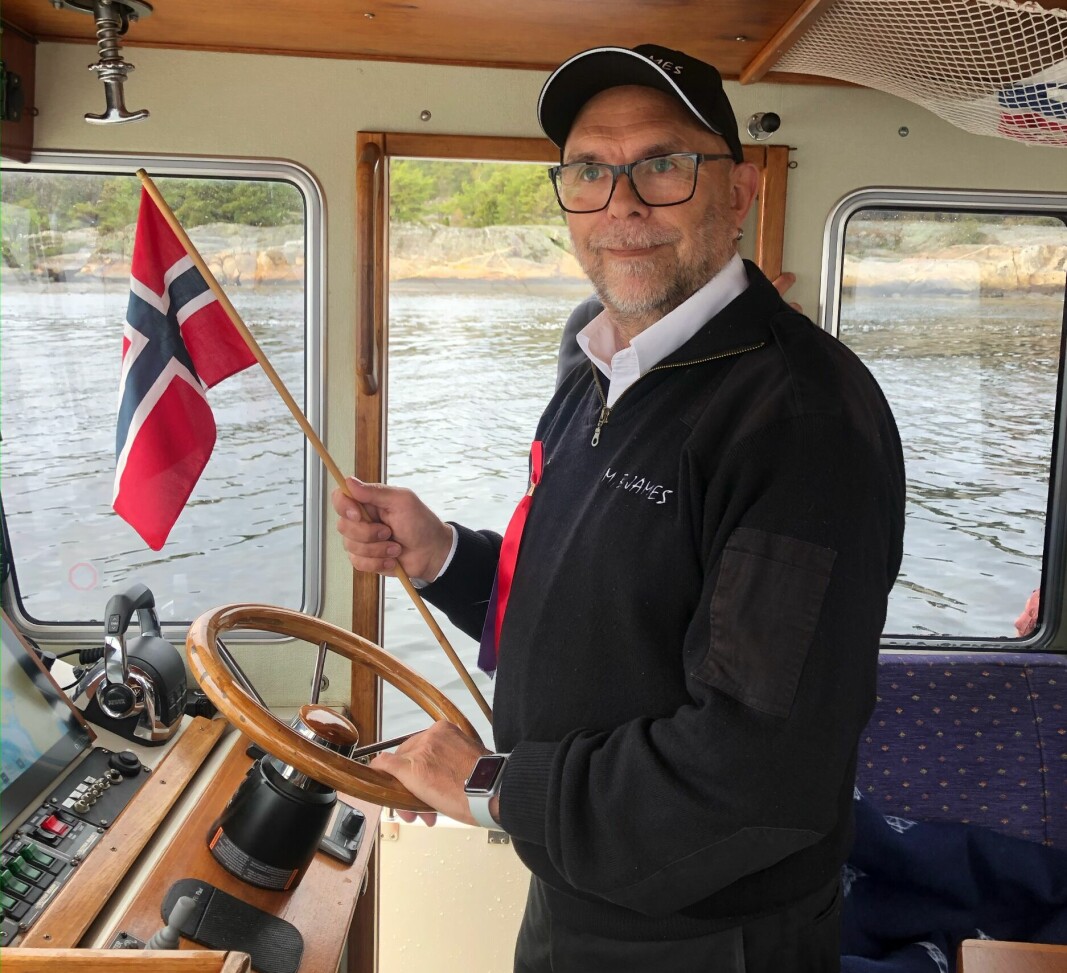 Knut Egil Knutsen i kjent stil bak roret på M/B James, taxibåten som han fører til daglig. Knutsen tar nok en gang initiativ til båtkortesje på 17. mai. Og metereologene lover pent vær på Hvaler, så alt skulle ligge til rette for en fin tur på sjøen.