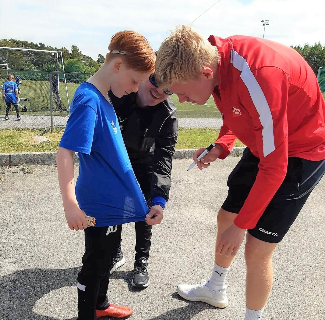 Tage Johansen signerte drakter. Her får en stolt, ung fotballspiller navnet til FFK-gutten på drakten. Tage Johansen signerte drakter. Her får en stolt, ung fotballspiller navnet til FFK-gutten på drakten.
