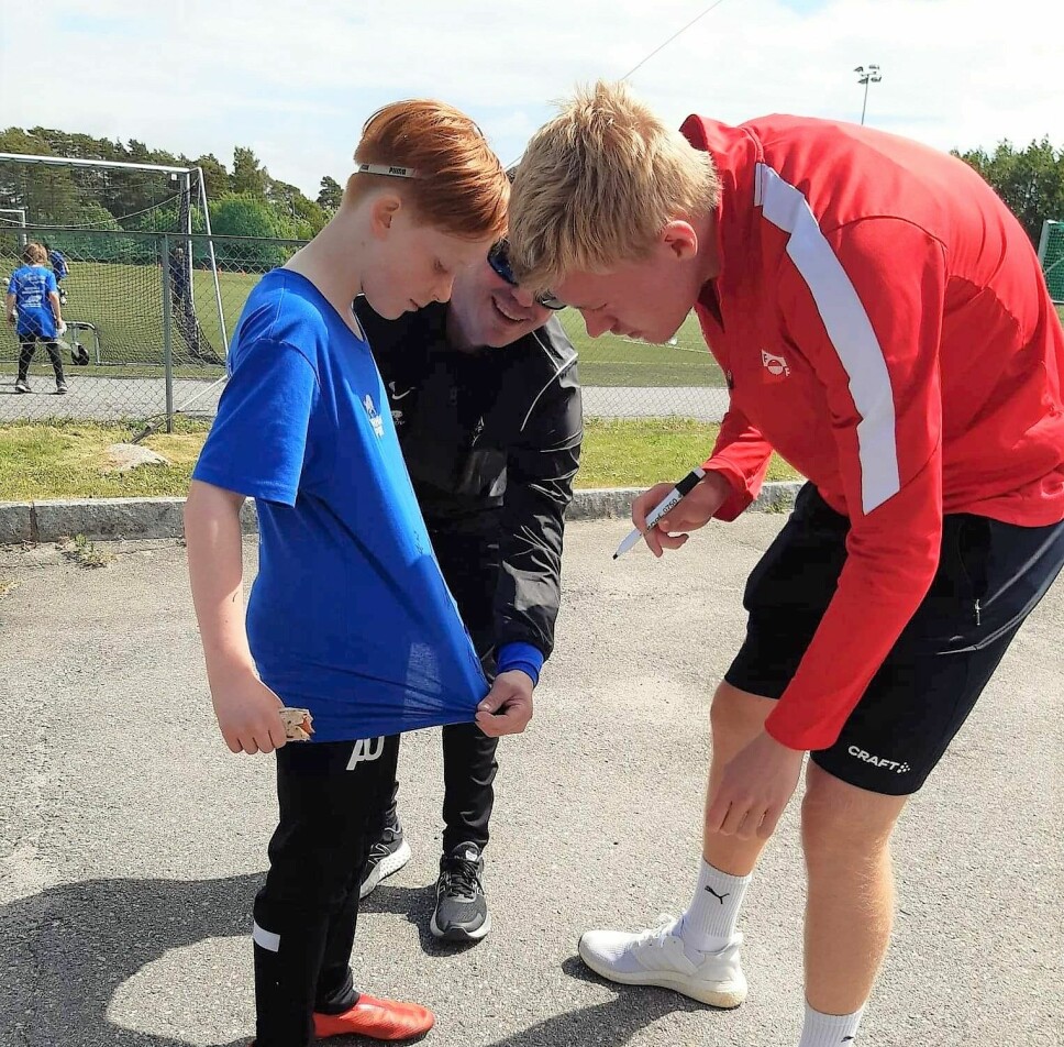 Tage Johansen signerte drakter. Her får en stolt, ung fotballspiller navnet til FFK-gutten på drakten.
