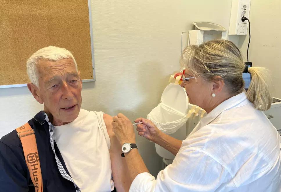Her får Nils Haarbye sin fjerde vaksinedose av sykepleier Anne Pøhner.