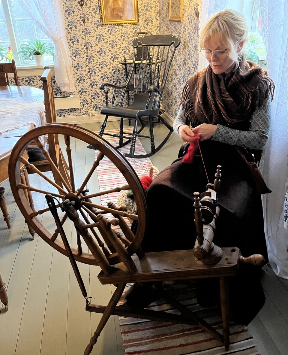 Ordfører Mona Vauger i gang med å spinne garn på rokken i stua på hovedbygningen.